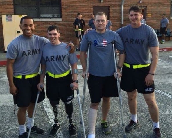 Army service members pose in their PT uniform
